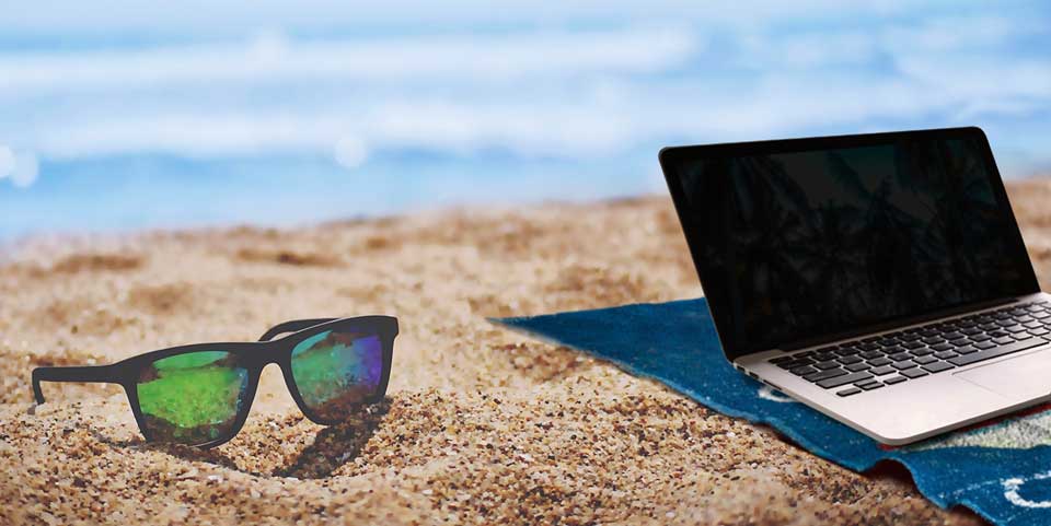 Laptop and sunglasses on a beach